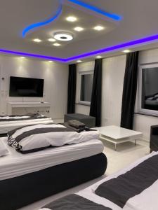 um quarto com 2 camas e uma luz azul no tecto em Aparts House - Balkon-WiFi-Kitchen em Essen