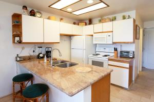 uma cozinha com armários brancos e uma bancada em Hale Kamaole 315 em Wailea
