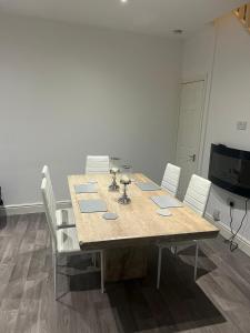 stół jadalny z białymi krzesłami i telewizor w obiekcie Silver Dream w Southend-on-Sea