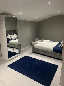 a bedroom with two beds and a blue rug at Silver Dream in Southend-on-Sea