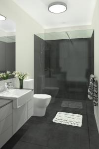 a bathroom with a toilet and a sink and a shower at Salt at Oceanside in Kawana Waters