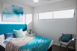カワナ・ウォーターズにあるSalt at Oceansideのベッドルーム1室(ベッド1台、窓、椅子付)