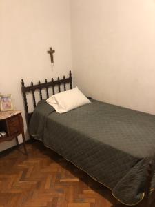 1 dormitorio con 1 cama y 1 cruz en la pared en Departamento centrico en mendoza en Mendoza