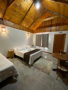 a large room with a bed and a table at Pousada Rural Pavão in Urubici