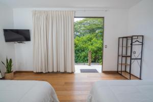 a bedroom with two beds and a large window at Equinoccio Hotel in Santa Ana