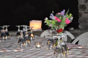 una mesa con flores en jarrones de cristal. en Locanda La Corte, en Serramezzana