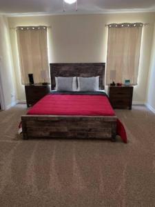 a bedroom with a large bed with a red blanket at King's Camp - SEAWORLD and MEDICAL Center, Yard, BBQ, Garage in San Antonio