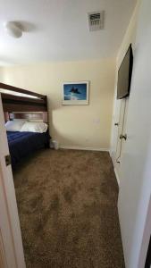 Dormitorio pequeño con cama y TV en King's Camp - SEAWORLD and MEDICAL Center, Yard, BBQ, Garage, en San Antonio