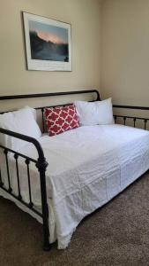 a bed with a black frame and white sheets and pillows at King's Camp - SEAWORLD and MEDICAL Center, Yard, BBQ, Garage in San Antonio