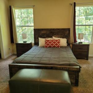 a bedroom with a large bed with two windows at King's Camp - SEAWORLD and MEDICAL Center, Yard, BBQ, Garage in San Antonio