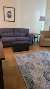 a living room with a blue couch and a chair at King's Camp - SEAWORLD and MEDICAL Center, Yard, BBQ, Garage in San Antonio
