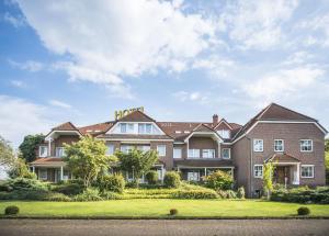 an exterior view of a large house at Hotel Hennies in Isernhagen