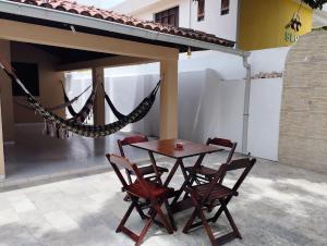 einen Tisch und Stühle sowie eine Hängematte auf der Terrasse in der Unterkunft A Oca Hostel Bar in João Pessoa