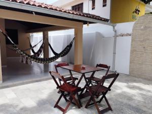 a table and chairs and a hammock on a patio at A Oca Hostel in João Pessoa