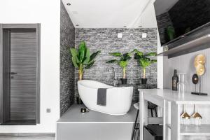 uma casa de banho com uma banheira branca e plantas em Luxury room Ekstaza em Solin