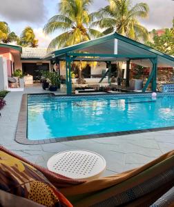 a swimming pool with a gazebo next to a resort at Mini boutique resort exclusively for your family or friends in Willemstad