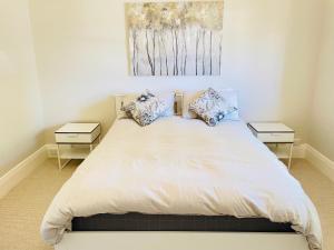 ein Schlafzimmer mit einem großen Bett mit zwei Nachttischen in der Unterkunft Classic Meets Modern in Central Wagga in Wagga Wagga