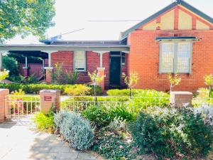 a brick house with a garden in front of it at Classic Meets Modern in Central Wagga in Wagga Wagga