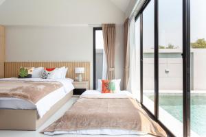 a bedroom with two beds and a large window at Private Pool Villa Newly-built Vimalai house in Pattaya in Nong Prue