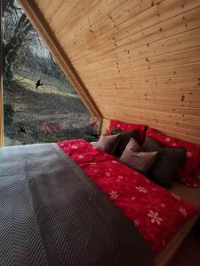 a bed with red sheets and pillows in a room at Srub Pod Lípou - Skryje 