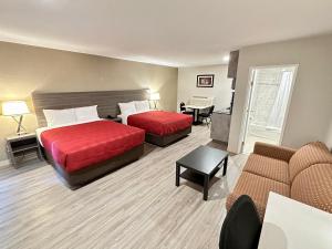 a hotel room with two beds and a couch at Econo Lodge Inn & Suites in Pincher Creek