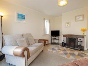 Una sala de estar con un sofá y una chimenea. en 5 Carlyon Road, en Truro