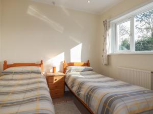 2 camas en un dormitorio con ventana en 5 Carlyon Road, en Truro