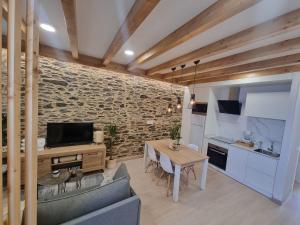 a kitchen and living room with a table and a couch at A CASIÑA DE ISABEL in Arzúa