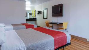 um quarto de hotel com duas camas e uma televisão em Motel 6-Bay Minette, AL em Bay Minette