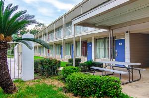 a building with a picnic table in front of it at Motel 6-Bay Minette, AL in Bay Minette