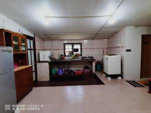 a kitchen with a refrigerator and a counter top at MK AL-ATTAS HOMESTAY - KUALA BESUT in Kampong Nail