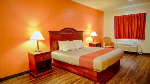 um quarto de hotel com uma cama e duas lâmpadas em Motel 6-Atoka, OK em Atoka