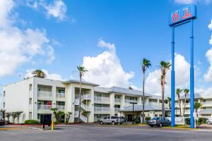 um hotel com palmeiras em frente a um parque de estacionamento em Studio 6-Corpus Christi, TX - North em Corpus Christi