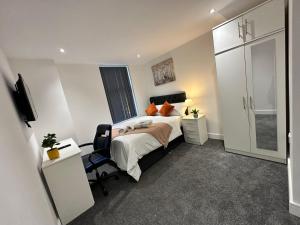 1 dormitorio con cama, escritorio y silla en Regent 28 en Coventry