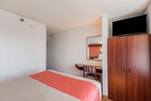 ein Hotelzimmer mit einem Bett und einem Flachbild-TV in der Unterkunft Motel 6-Olathe, KS in Olathe