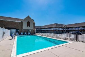 a swimming pool with chairs in front of a building at Motel 6-Portsmouth, VA in Portsmouth