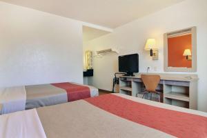 um quarto de hotel com duas camas e uma secretária com uma televisão em Motel 6-San Angelo, TX em San Angelo
