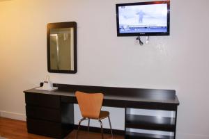 a desk with a mirror and a television on a wall at Motel 6-Goodland, KS in Goodland