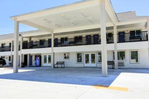 a large white building with balconies and a parking lot at Motel 6-Rockport, TX in Rockport