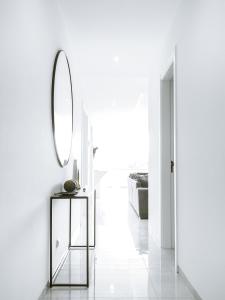 a white hallway with a mirror and a table at Filomena Apartments LUXURY in Mindelo