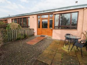 a house with a table in front of it at Nuthatch in Ivegill