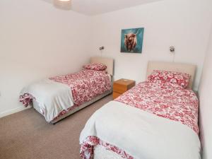 1 dormitorio con 2 camas y una foto de un caballo en la pared en Woodpecker en Ivegill
