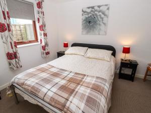 a bedroom with a bed and two lamps and a window at Nuthatch in Ivegill