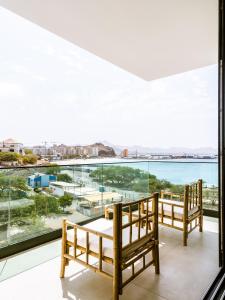 two benches on a balcony with a view of the water at Filomena Apartments LUXURY in Mindelo
