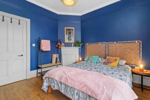 Schlafzimmer mit blauen Wänden und einem Bett in der Unterkunft Clinton Place in Seaford