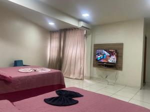 戈亞尼亞的住宿－El Nassr suits，一间卧室配有一张床,并在一间客房内配有电视。