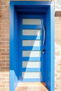 a blue door in front of a brick building at Sky Home - Two Bedroom Loft Townhouse with Bay Views in Sydney