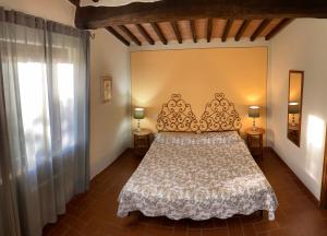 a bedroom with a bed and two lamps on two tables at Coliberto in Massa Marittima