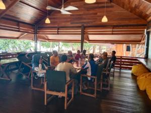 a group of people sitting at a table in a restaurant at Andau Resort Raja Ampat in Tapokreng