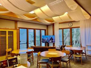 a restaurant with tables and chairs and a tv at 湯布院 星の里 Yufuin Hoshinosato in Yufuin